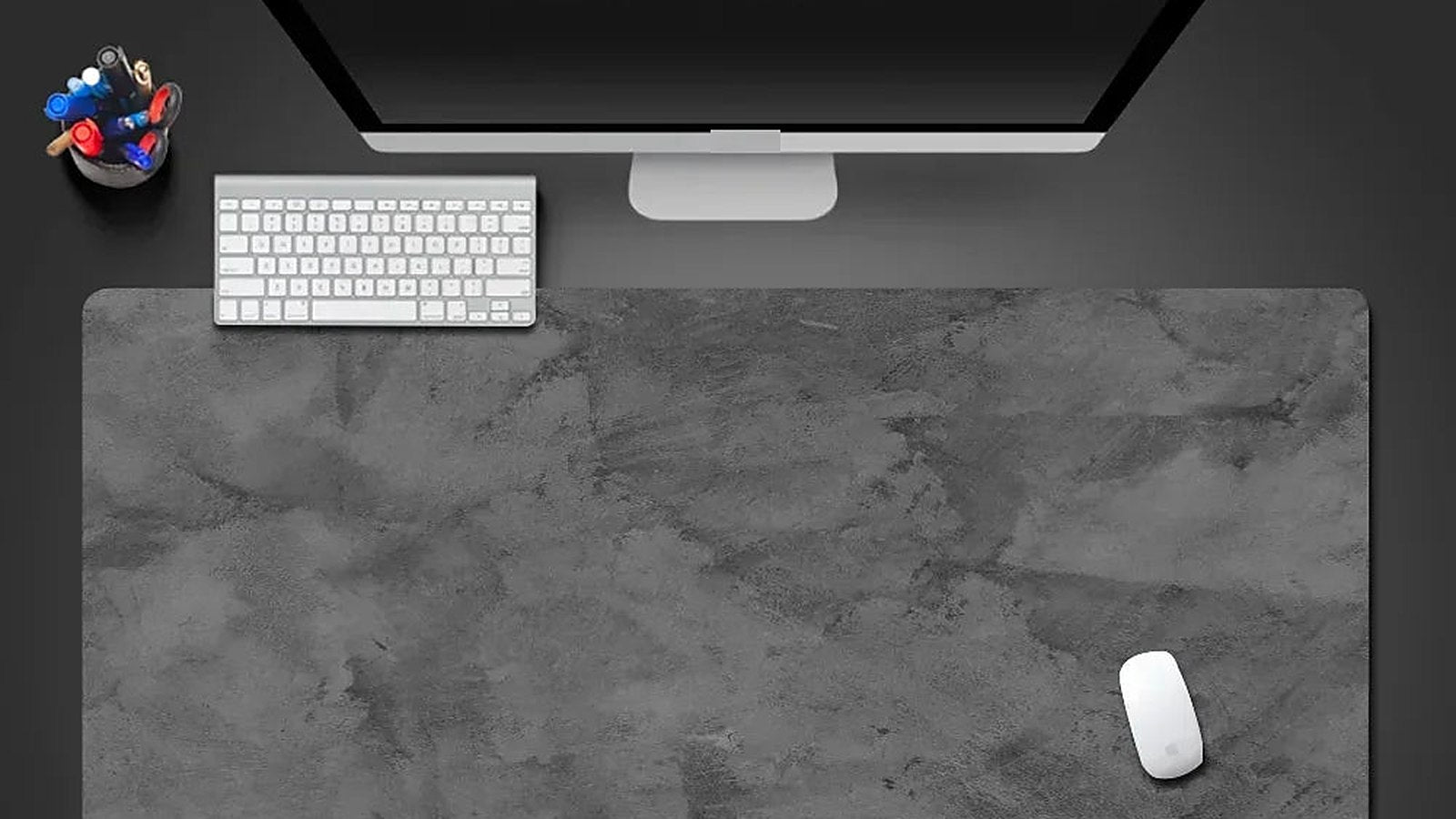 A tidy desk seen from above with a large mat, keyboard and mouse and no visible cables