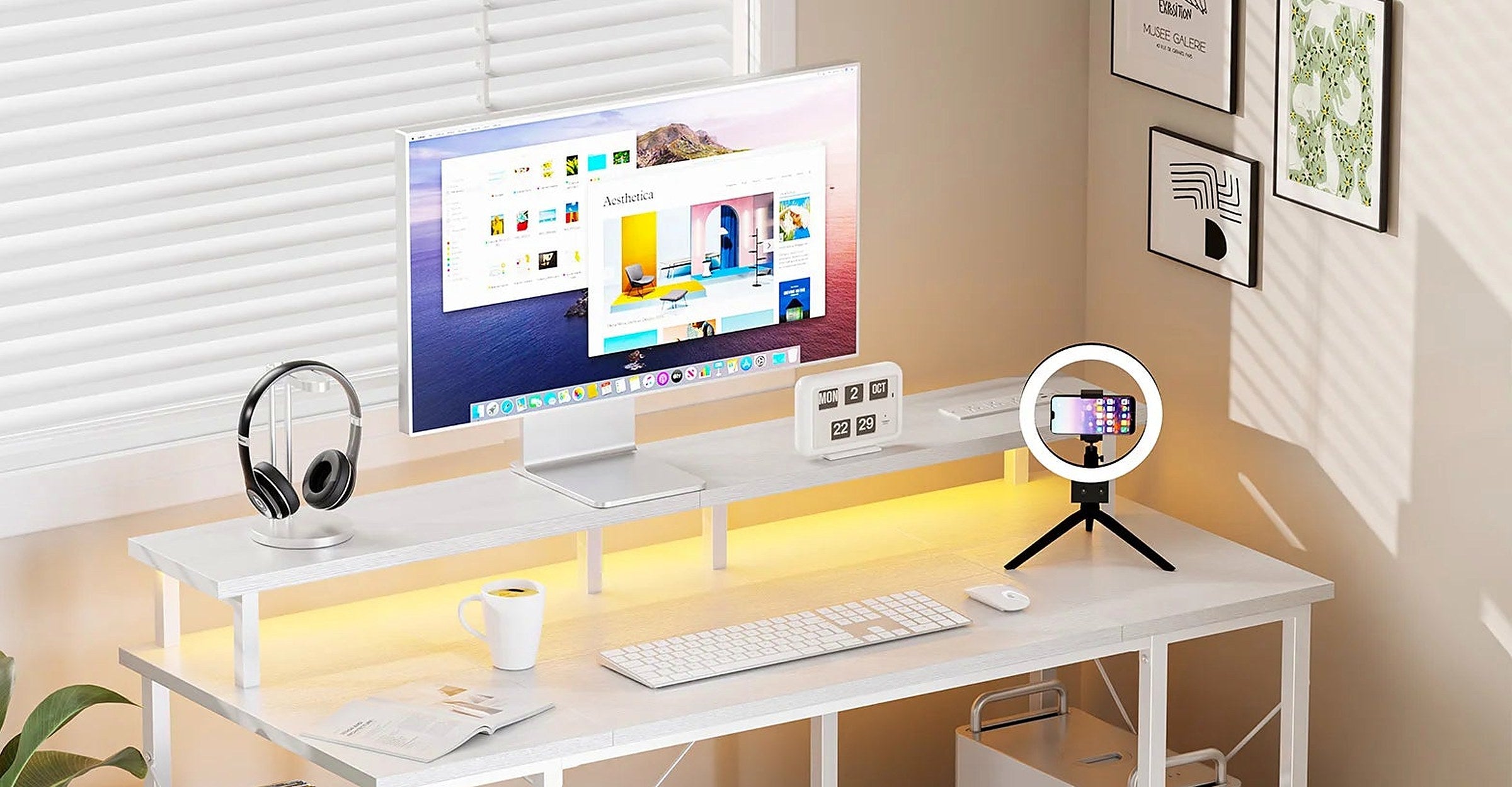 A home office desk with a monitor, keyboard and headphones under warm light